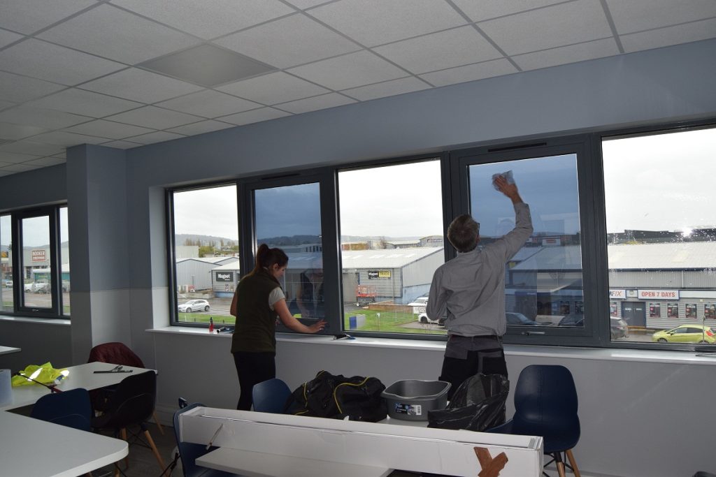 Rest room heat reduction window film installation in progress